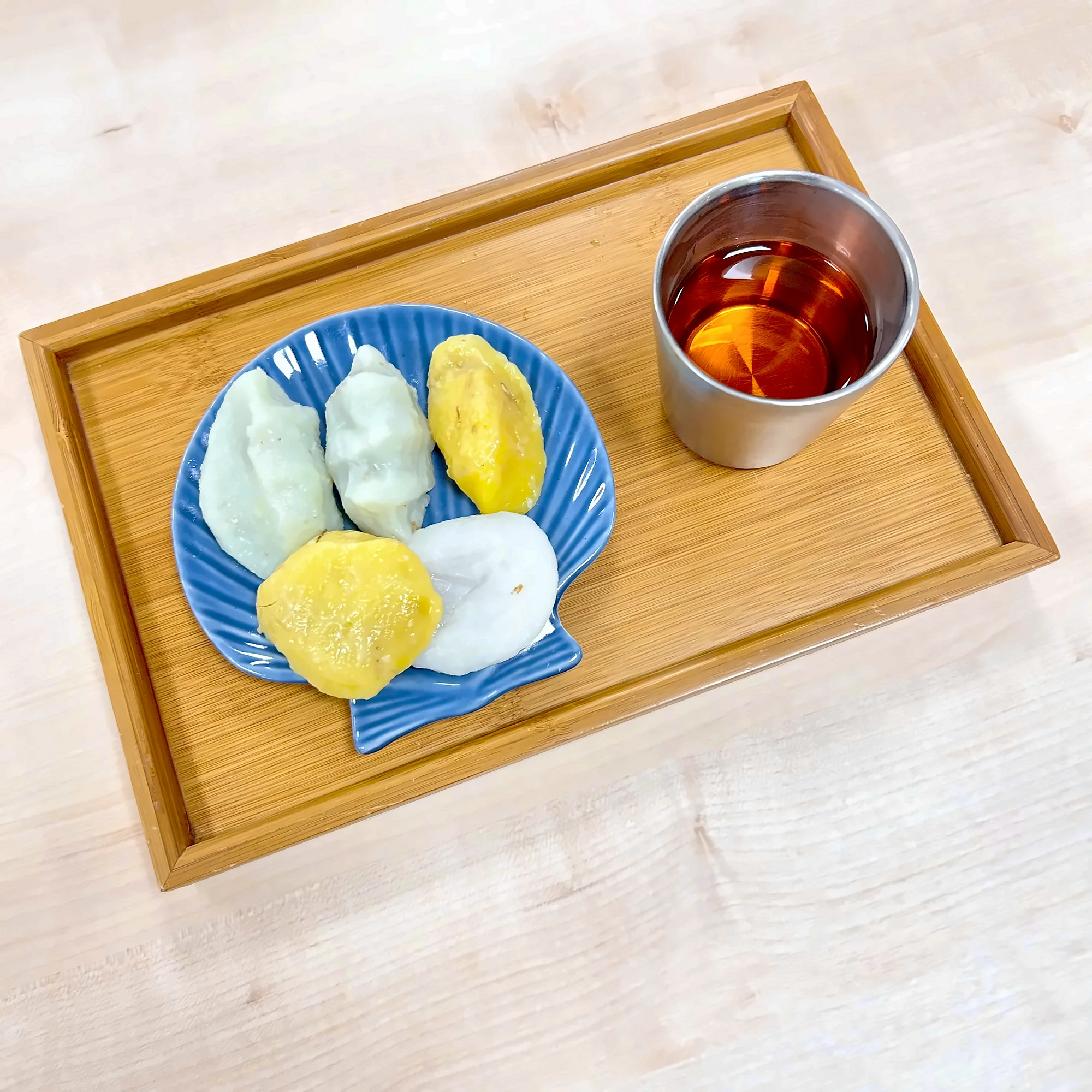 쟁반 위 파란 접시에 담은 삼색 송편과 차 한 잔